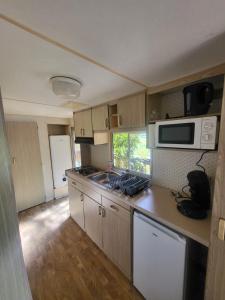 una piccola cucina con fornelli e forno a microonde di Le Chalet de Moissac a Moissac