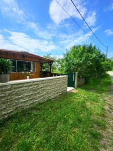 una casa con un muro di contenimento e una recinzione di Le Chalet de Moissac a Moissac Altre 8 foto