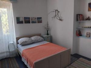 a bedroom with a bed with an orange blanket at Beko i Dada in Olib