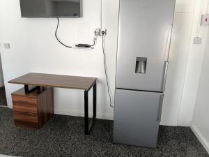 a desk next to a refrigerator and a table at Liv's place in Oldbury +28 photos