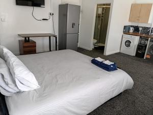 a white bed with a blue bag on top of it at Liv's place in Oldbury