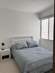 a white bedroom with a bed and a window at Casa Rafaela in Santa Elena