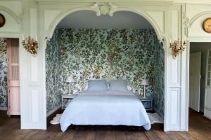 a bedroom with a bed with a floral wallpaper at Castel de Grafeuille in Hautefage