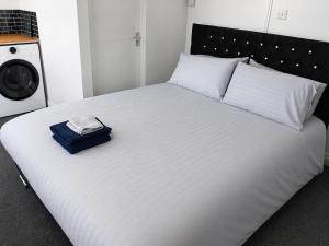 a large white bed with a blue bag on it at Liv's place in Oldbury