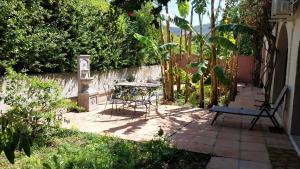 a patio with a table and chairs in a garden at Casa Papaver Relax Appartement in Coín