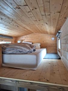 a bed in a room with a wooden ceiling at Tiny House - Cottages - Mobilhomes - Camping Les Granges Bas in Gérardmer +71 photos