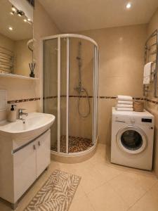 a bathroom with a shower and a washing machine at Apartamentai Palangoje Arune in Palanga +77 photos
