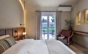 a bedroom with a bed and a chair and a window at DOMUS GEORGiO in Litochoro