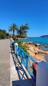 a blue fence next to a beach with a palm tree at The Beach House in Porto Rafti