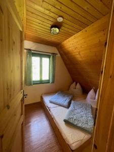 a small room with a bed in a wooden cabin at Berghütte am Grenzwinkel in Sebnitz