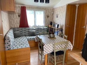 a living room with a table and a couch at mobil home 3 chambres in Pataias
