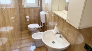 a bathroom with a white toilet and a sink at Casa Cretier in Aosta