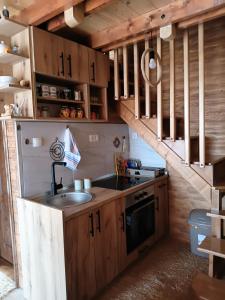 a kitchen with wooden cabinets and a sink and a staircase at Vila Prevoja in Nova Varoš +10 photos