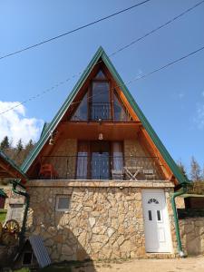 a stone house with a porch and a balcony at Vila Prevoja in Nova Varoš
