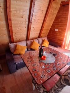 a room with a table and a couch with a table and a wine bottle at Vila Prevoja in Nova Varoš