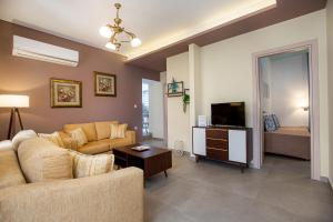 a living room with a couch and a television at Villa Pines in Limenaria
