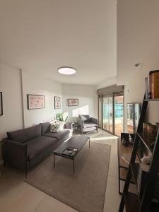 a living room with a couch and a table at Sunset suite - step from the beach in Ashkelon