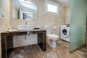 a bathroom with a sink and a washing machine at Villa Pines in Limenaria +53 photos