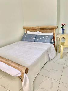 a bedroom with a bed with blue pillows and a table at Nol's Inn in Iloilo City