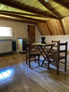 a table and chairs in a room with a kitchen at Abrigo Pedrão in Pedralva
