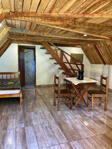 a room with a table and chairs and a staircase at Abrigo Pedrão in Pedralva