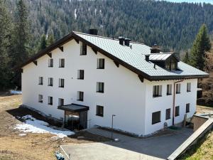 a large white building with trees in the background at Ferienwohnung Haus Ginseng in Davos