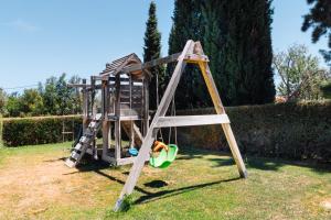 a wooden swing set in a yard at Casa Porta Azul in Boliqueime