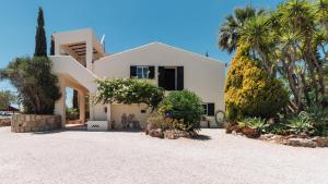 a white house with palm trees in front of it at Casa Porta Azul in Boliqueime