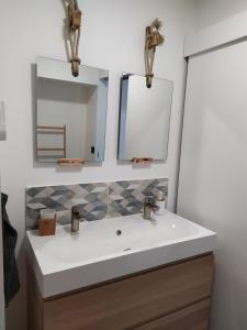 a bathroom with a sink and two mirrors at Calme et Volupté in Maxilly-sur-Saône