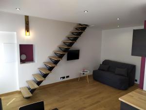 a living room with a blue couch and a staircase at Calme et Volupté in Maxilly-sur-Saône