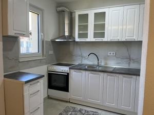 a kitchen with white cabinets and a sink at Al Noor Villa Ilidža in Ilidža