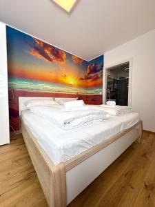 a bedroom with a large bed with a painting on the wall at Beach SUN and FUN in Podersdorf am See +27 photos