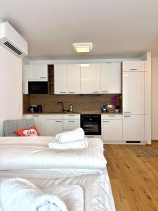 a room with two beds and a kitchen with white cabinets at Beach SUN and FUN in Podersdorf am See