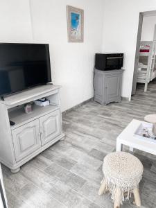 a living room with a flat screen tv on a entertainment center at STUDIO REFAIT À NEUF BORD DE MER in Six-Fours-les-Plages