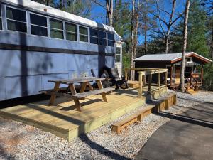 a picnic table and a bus next to a picnic table at Lazy T Cabins - The Skoolie in Robbinsville