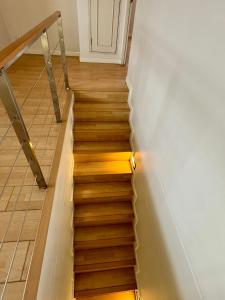 a staircase with wooden floors and a white wall at Duplex 21 Apartment in Bangkok