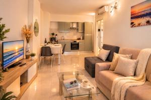 a living room with a couch and a table with a tv at Vacanze Residence Mimose - con parcheggio relax tra pineta e spiaggia in Eraclea Mare