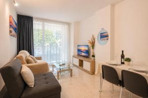 a living room with a couch and a table and a television at Vacanze Residence Mimose - con parcheggio relax tra pineta e spiaggia in Eraclea Mare