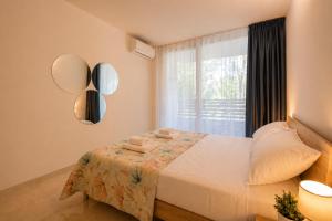 a bedroom with a large bed and a window at Vacanze Residence Mimose - con parcheggio relax tra pineta e spiaggia in Eraclea Mare