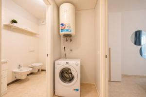 a bathroom with a washing machine and a toilet at Vacanze Residence Mimose - con parcheggio relax tra pineta e spiaggia in Eraclea Mare +14 photos
