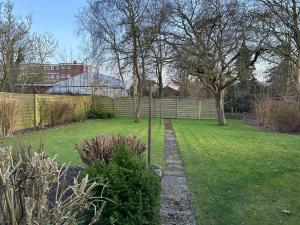 a garden with a fence and a grass yard at Ferienhaus Husum Nordsee in Husum