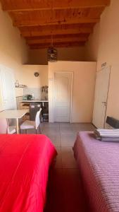 a room with two beds and a table and a kitchen at Casa Choique in Villa El Chocón