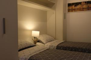 two twin beds in a room with a lamp at L'Ancora in Rapallo