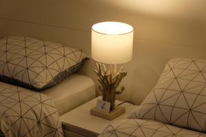 a lamp sitting on a table next to two beds at L'Ancora in Rapallo