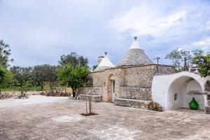 a large stone building with a tower on top at Trullo MaPì in San Michele Salentino