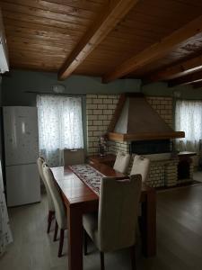 a dining room with a table and chairs and a kitchen at Forest Escape House in Begovo Razdolje