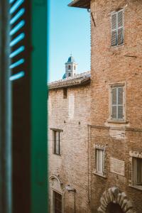 a brick building with a tower on top of it at Loft Raffaello 22 in Urbino
