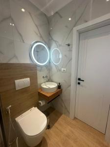 a bathroom with a toilet and a sink and a mirror at Seli's White Villa in Ksamil +30 photos