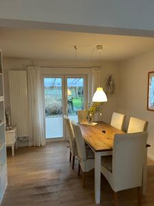 a dining room with a wooden table and chairs at Ferienhaus Husum Nordsee in Husum