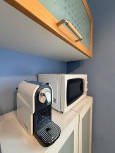a microwave sitting on top of a counter at Chicco Light - Appartamento low cost per soggiorni brevi Vercelli Wi-Fi - Cinelli Apartment in Vercelli